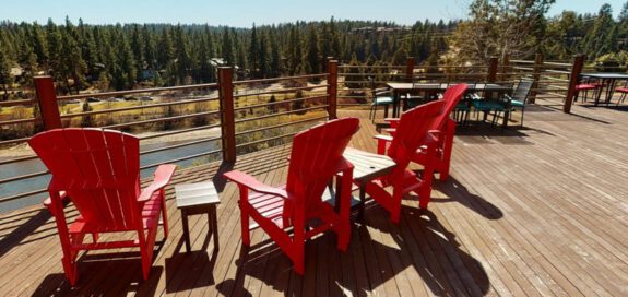 The deck at The Haven on a sunny day with red lounge chairs.