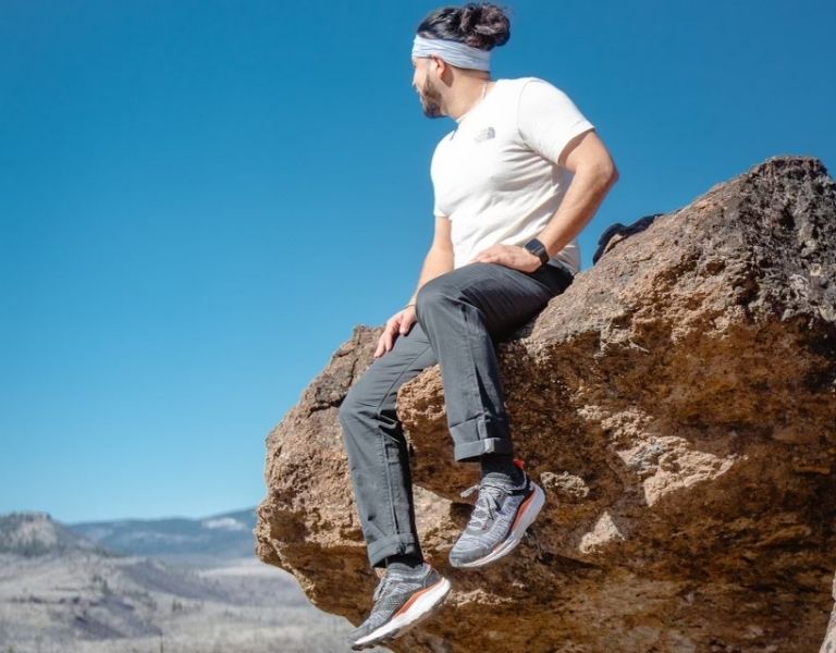 Zavier Borja sits on a rock cliff overlooking Central Oregon