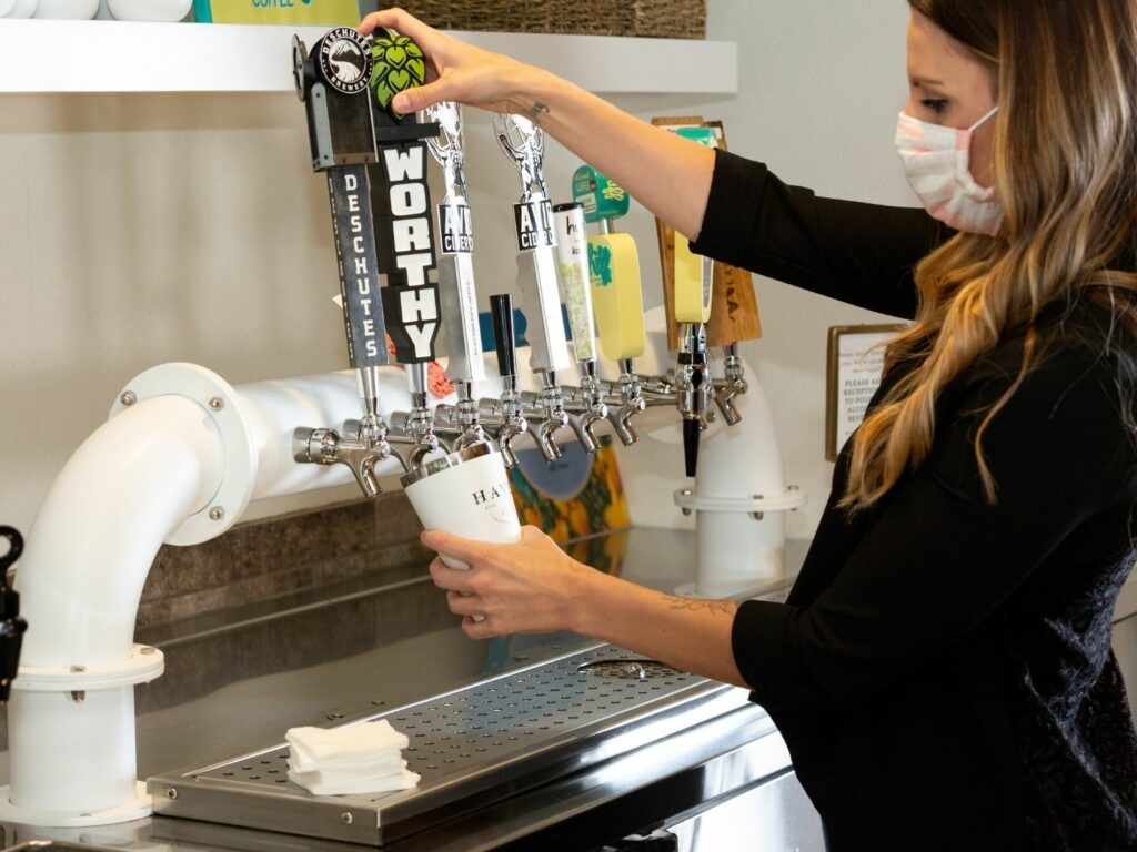 woman pours a tap of beer from a local bend oregon vendor worthy brewing