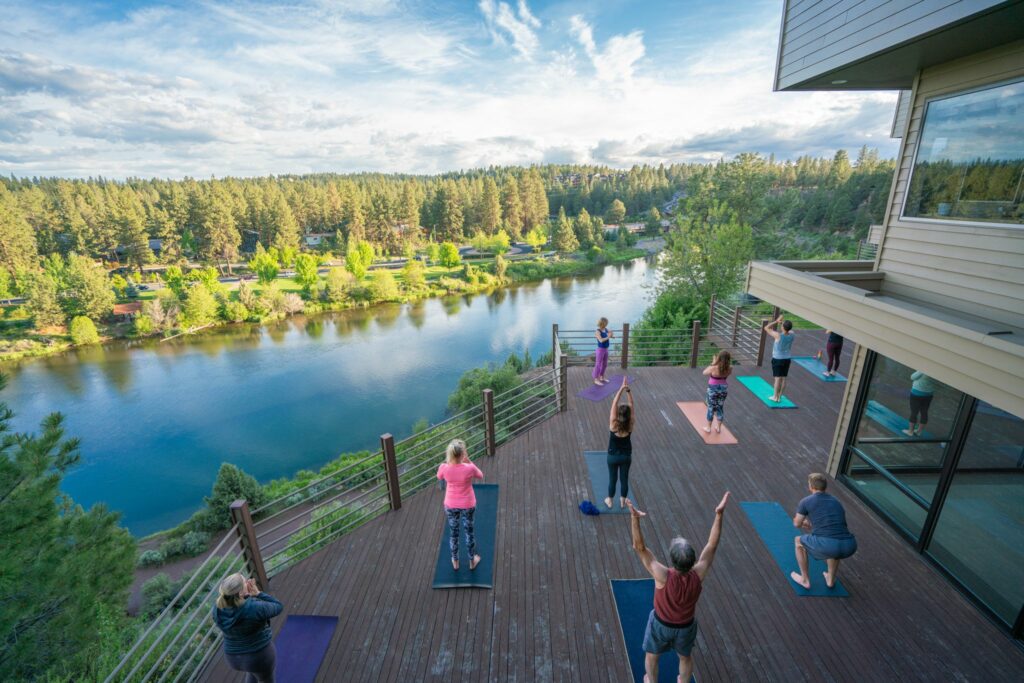View of people doing yoga on a deck overlooking deschutes river as a part of Springtime Activities for Haven Members