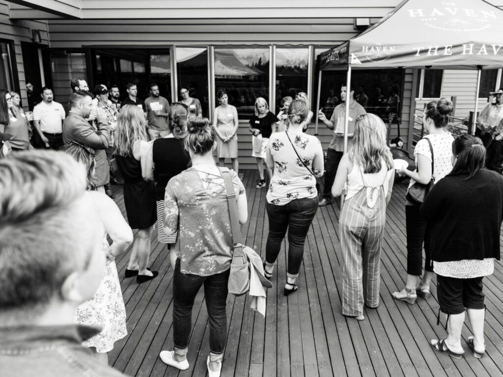 black and white photo of people gathered on a deck networking for an event